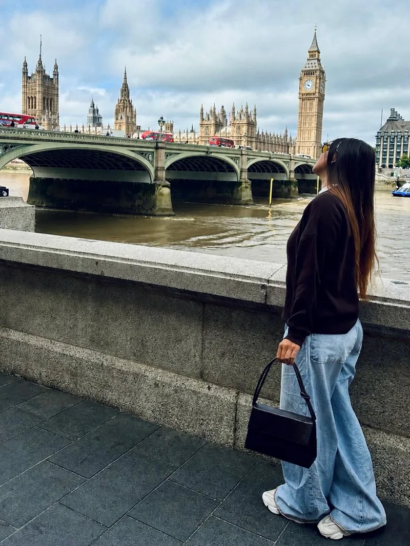 A Ester olhando para o Big Ben, do outro lado do rio Tâmisa.